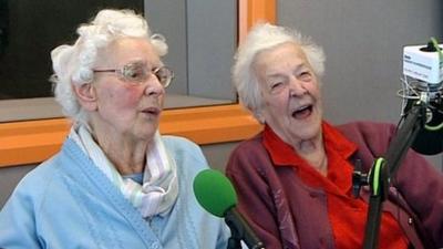 Beryl and Betty talking in front of the mic