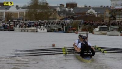 Swimmer's head bobbing in water ahead of Oxford crew