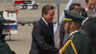 David Cameron disembarks from aircraft in Tokyo.