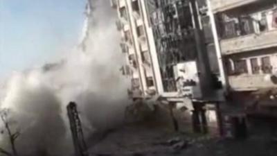 Military explosion on the front of a building in the Syrian city of Homs.