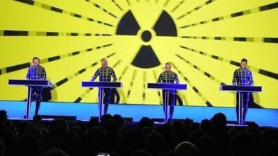 The band Kraftwerk performs in front of an atomic radiation symbol