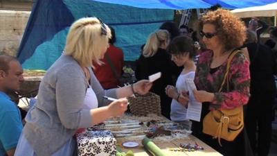 Woman hands over 'exchange' paper at bartering market.