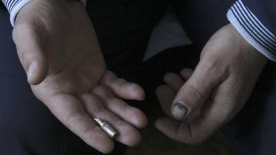 A hand holding a bullet