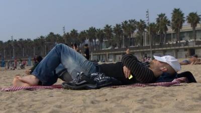 Man lies on beach in Barcelona