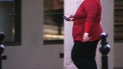 Obese woman walking down street