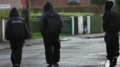 teenagers walking with their hoods up