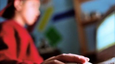 Blurred image of teenager boy at his computer