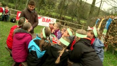 Ricky chatting to children at a countryside picnic table