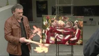 A painting by German artist, Astrid Stof, is set on fire in protest