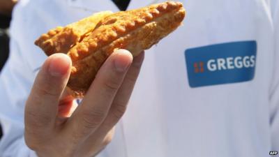 Greggs employer holding a pasty