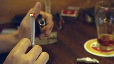 Cannabis joint being lit in coffee shop