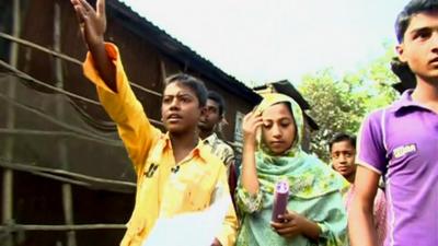 boy walking through a bangladesh village with other children