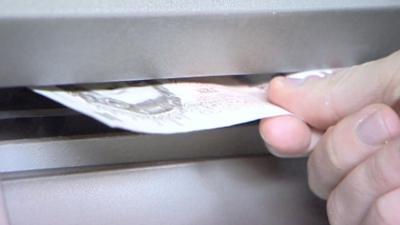 Money being taken from cash machine