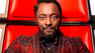 will.i.am in his red chair on the set of The Voice.