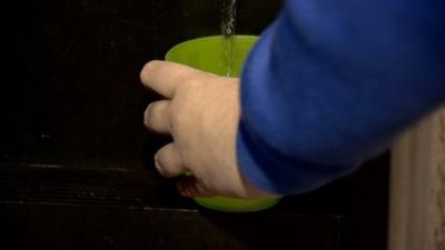 Teenager fills a cup of water