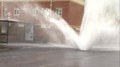 Water spraying from a burst water pipe in Gateshead