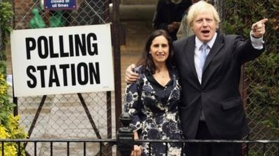 Boris Johnson, the current mayor of London, standing in front of a polling station with his wife.