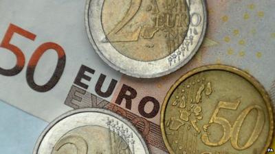 Euro coins on 50-euro note