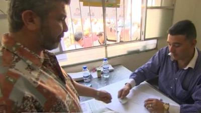 Man collecting voting papers in Syria