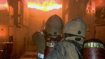 Firefighters tackle a burning building during a training exercise