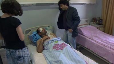 People visiting injured journalist in hospital bed