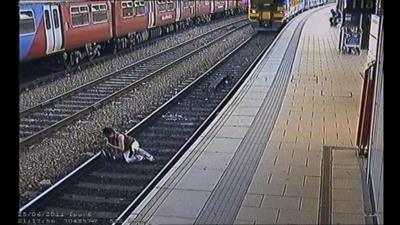 A woman stumbles in front of a train