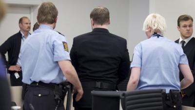 Anders Bering Breivik in court with security guards