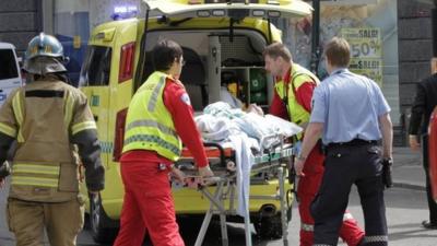 Medical staff load a man, who set himself on fire outside the Oslo courthouse where Anders Breivik is being tried, into an ambulance
