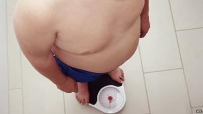obese child weighing himself