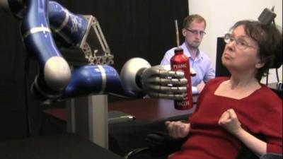 Cathy Hutchinson using a robot arm to take a sip of coffee - Courtesy Brown University