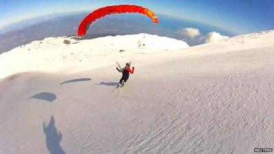 Paraglider flying over mountain