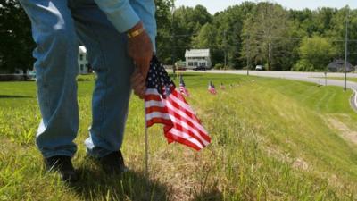 Jim Stull, 78, a life long resident of Thurmont, Md, places American flags along the exit ramp from Route 15 to Route 77