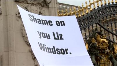 Protester's banner outside Buckingham Palace