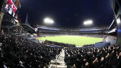 Orthodox Jews sit at Citi Field