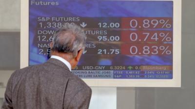 A man checks a stock exchange monitor in Milan, Italy