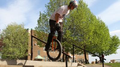 Hugo Duguay going down a rail on a unicycle