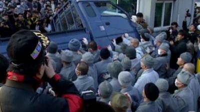 Rioting monks turn over a van