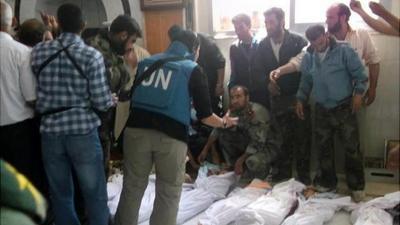 UN observers at a hospital morgue before their burial in the central Syrian town of Houla