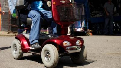 An anonymous person driving a mobility scooter