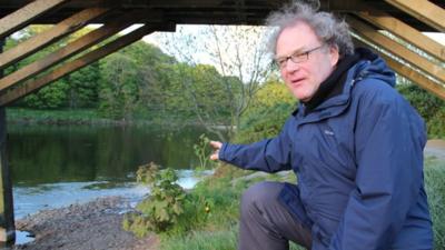 Aidan Turner-Bishop points to the spot on the River Ribble where the first Mormon baptisms in England took place