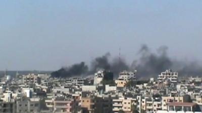 Smoke rises above buildings