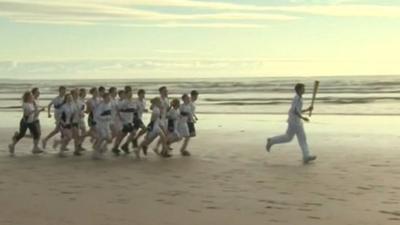 Thirteen-year-old Joseph Forester carries the torch on West Sands