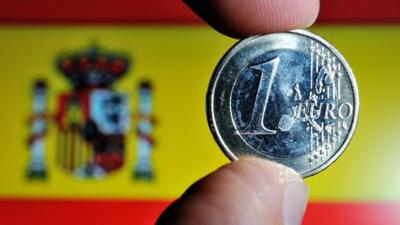 A coin of euro with a Spanish national flag