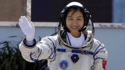 China"s first female astronaut Liu Yang waves during a departure ceremony at Jiuquan Satellite Launch Center