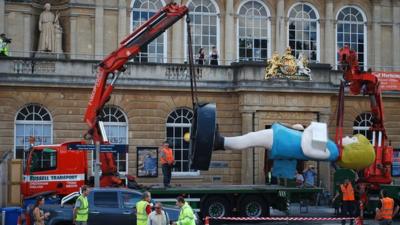 Two cranes being used to lift Charity onto a lorry