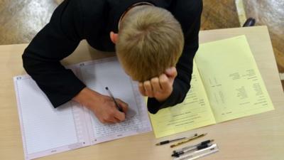 Boy writing during exam