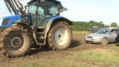 A tractor pulling out a car from the car park after the Isle of Wight Festival