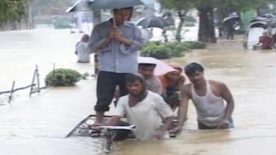 People in Bangladesh walking through floodwater