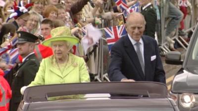 The Queen and Prince Philip in an open-topped vehicle