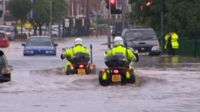 Police motorcycles in flood water